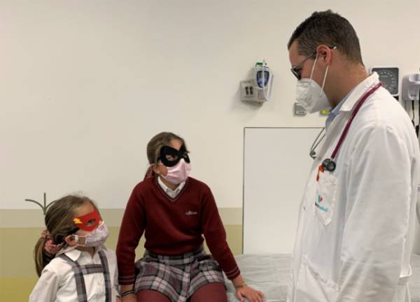 El pediatra Daniel Ruiz junto a dos pacientes con sus antifaces.