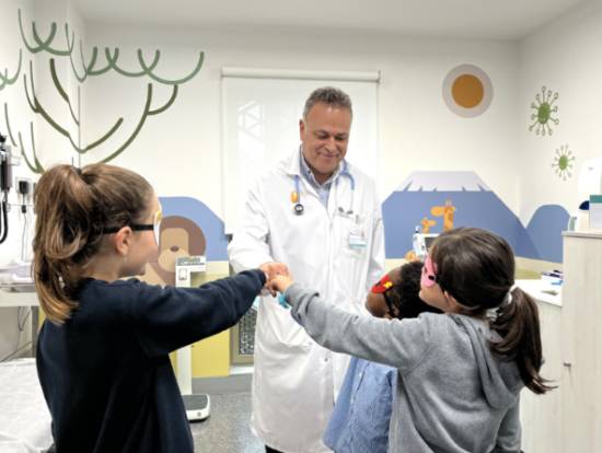 El doctor Francisco Javier Gascón junto a pacientes pediátricos en consulta.