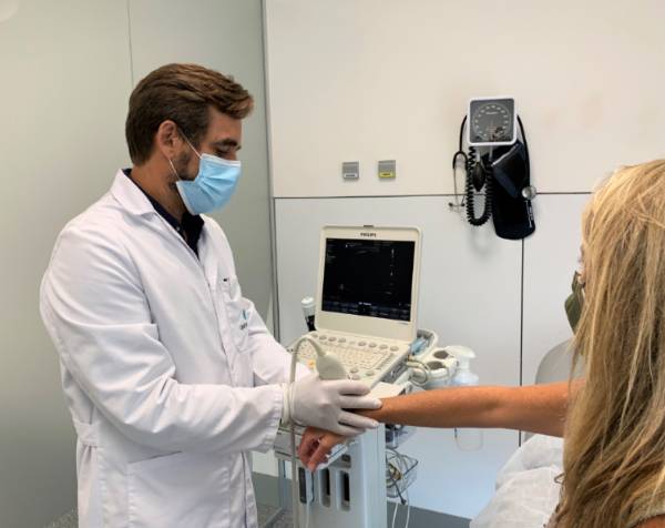El doctor Romero realiza una ecografía a una paciente en consulta.