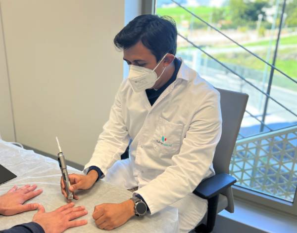 El doctor Juan Pablo Baldivieso realiza una capilaroscopia en consulta.