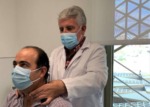 El doctor Palomares realiza un reconocimiento de un paciente en consulta.