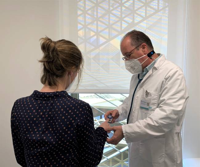 El doctor Entrenas realiza una medición de la saturación a una paciente en consulta.