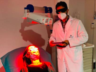 El Dr. aplicando la terapia fotodinámica a una paciente