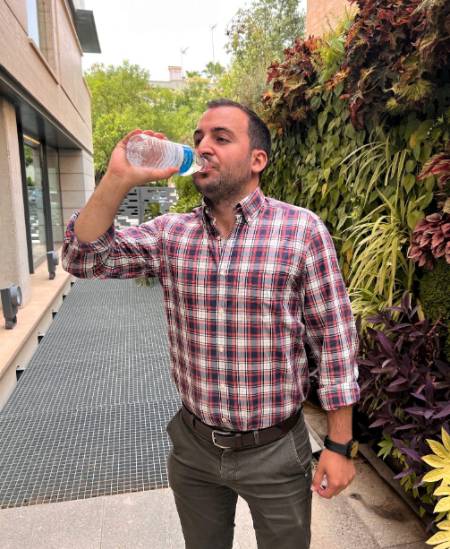 Un hombre bebe agua para evitar los efectos de la ola de calor.